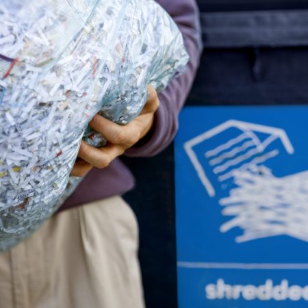A,Man,Recycling,A,Bag,Of,Shredded,Paper